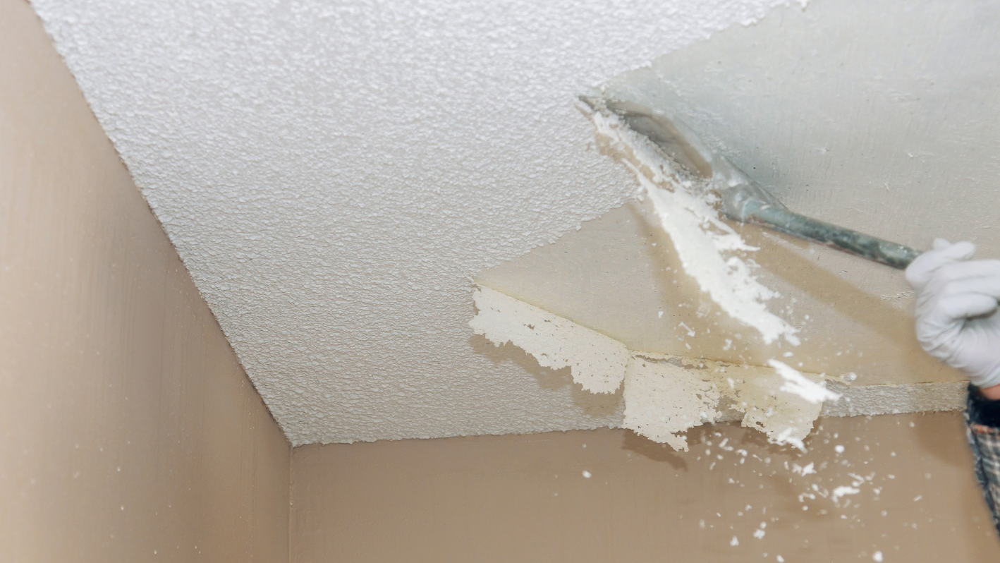 A person with a white glove is painting a ceiling